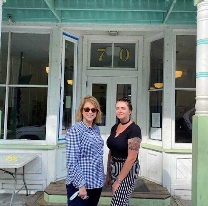 Two women standing outside of storefront